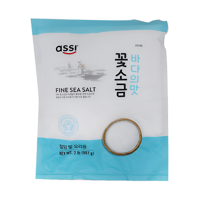 Packaging of Assi Fine Sea Salt, with a blue and white design, including a fine sea salt crystal on the front, and Korean and Vietnamese text indicating the product origin and flavor.