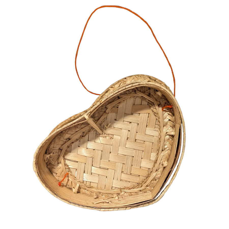 Heart-shaped wicker basket with a handle on a white background