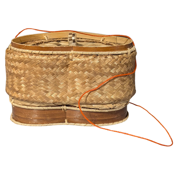Woven rice basket with an orange handle on a white background