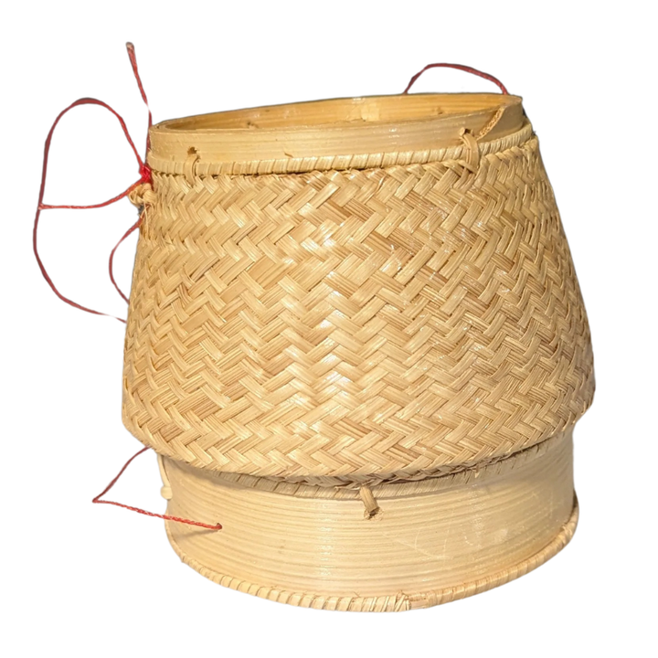 Woven bamboo basket with red string handles on a white background