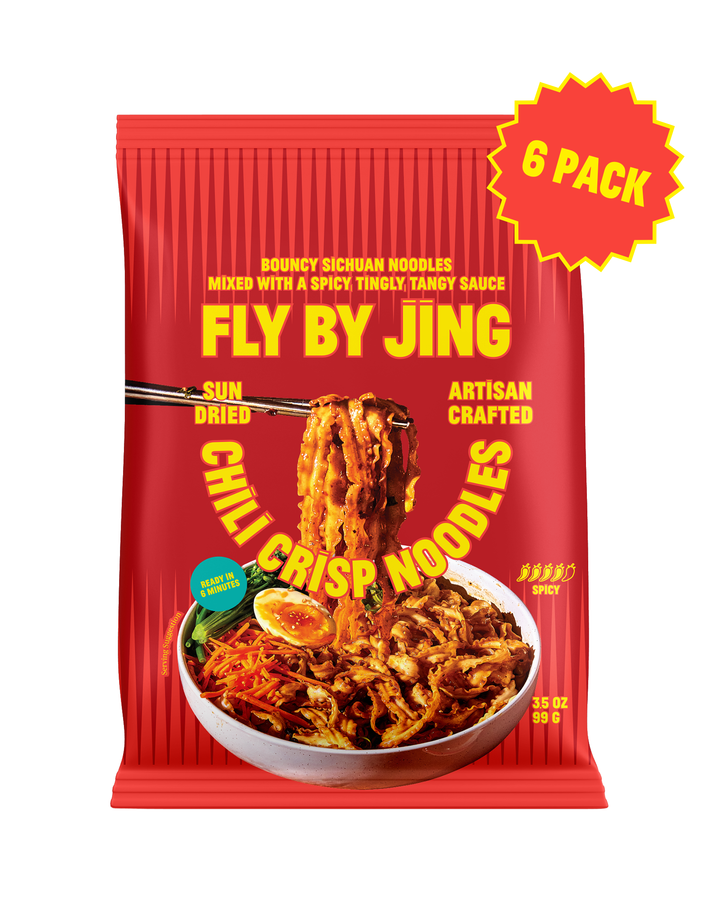 A red package of Fly By Jing Chili Crisp Noodles shown on a plain white background, with a yellow burst sticker reading &