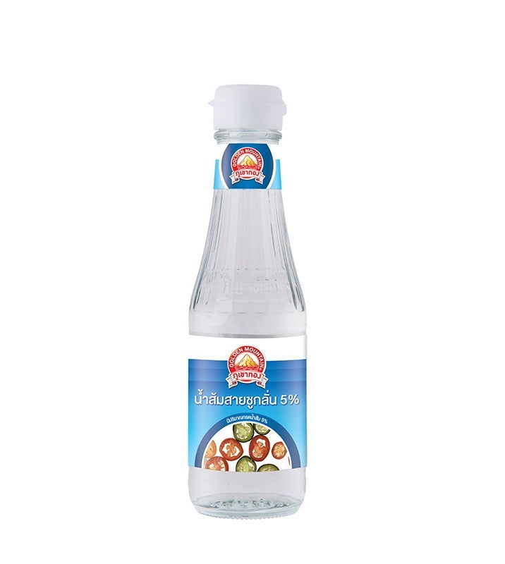 A small clear glass bottle of Golden Mountain Distilled Vinegar with a sky blue label featuring an image of colorful sliced Thai chili peppers in a small bowl of vinegar. 
