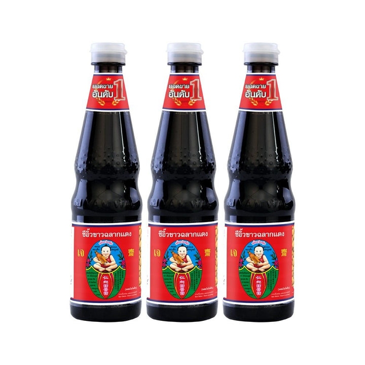 Three bottles of a dark liquid with red labels on a white background