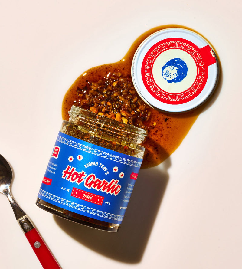 Jar of hot garlic sauce with a red and white label on a light background