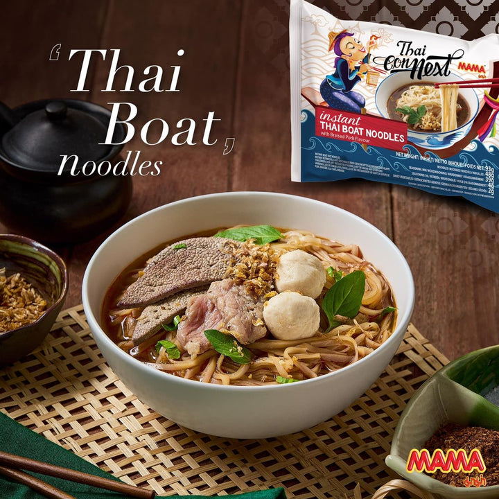 Bowl of Thai Boat noodles with a package of Mama instant Thai Boat Noodles on a wooden surface.