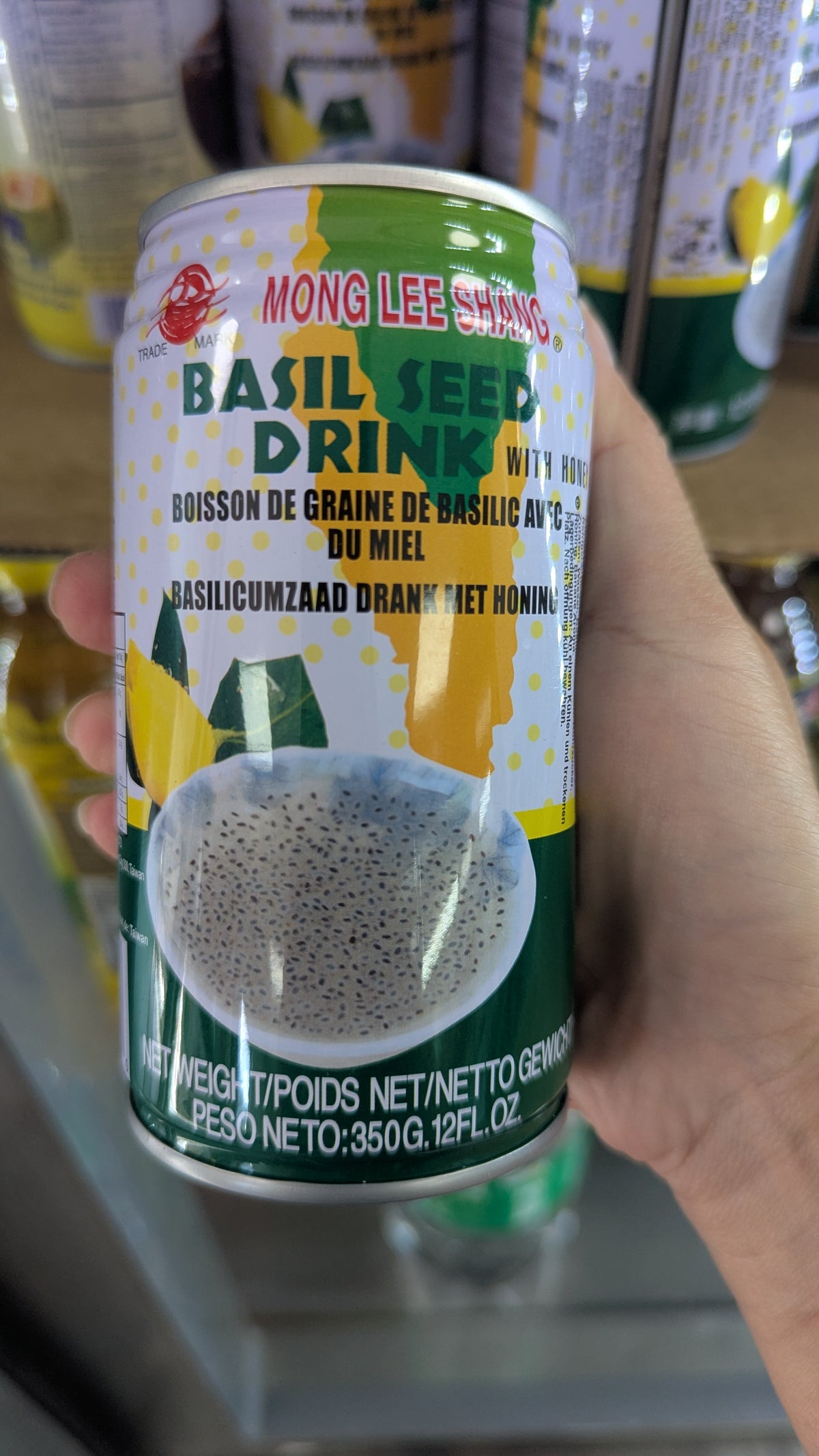 Can of Basil Seed Drink held by a hand with blurred background