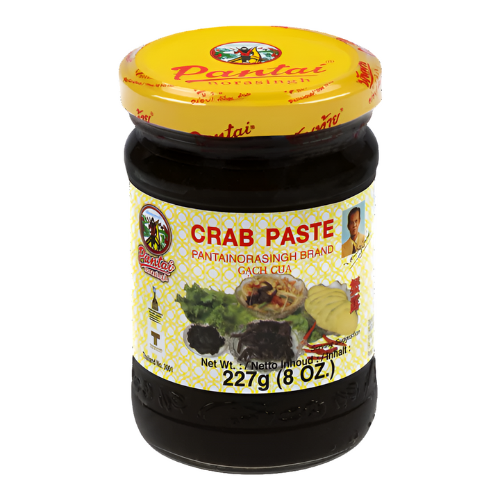 Jar of Pantai Norasingh brand fermented crab paste, 8 oz (227g), with a yellow lid and labeled in English and Thai.