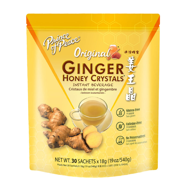 Yellow package of Prince of Peace Ginger Honey Crystals Instant Beverage with image of whole ginger and two sliced ginger near a clear cup and coaster.