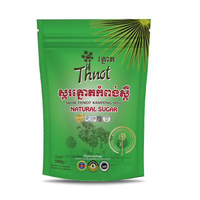 Green plastic package of Thnot natural sugar with red Khmer scripts, with images of palm trees.