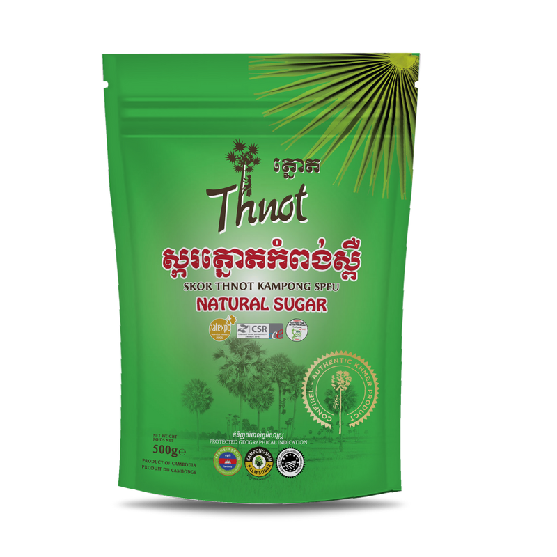 Green plastic package of Thnot natural sugar with red Khmer scripts, with images of palm trees.