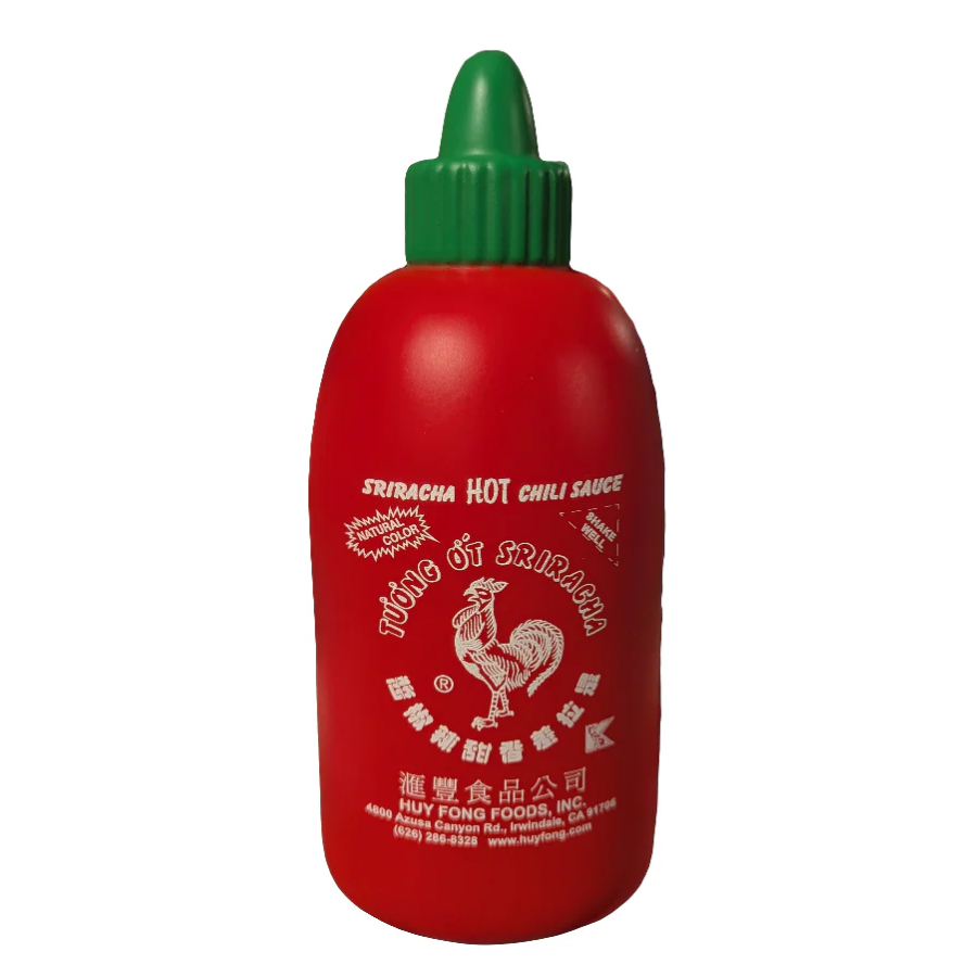 Red bottle of Sriracha hot chili sauce with a green cap on a white background