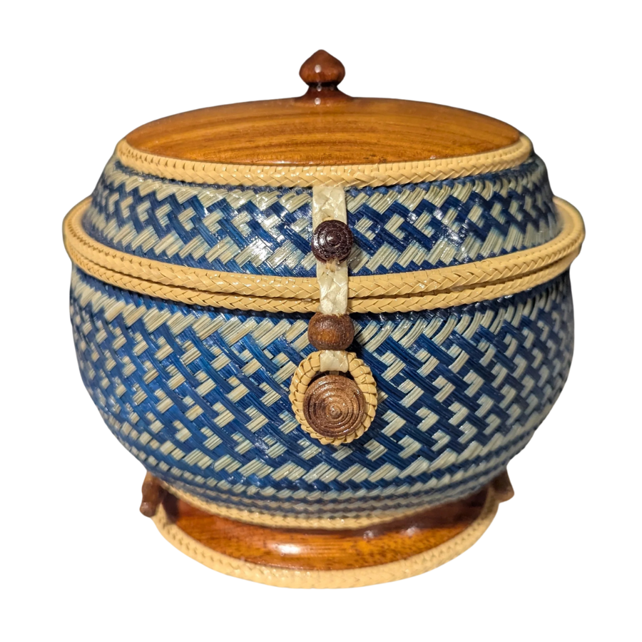Woven basket with blue geometric pattern and wooden lid on a white background