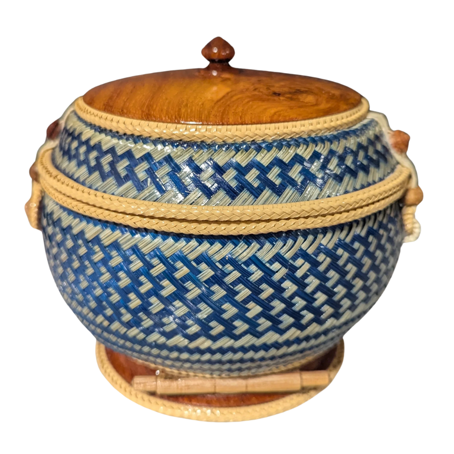 Woven basket with blue geometric pattern and wooden lid on a white background