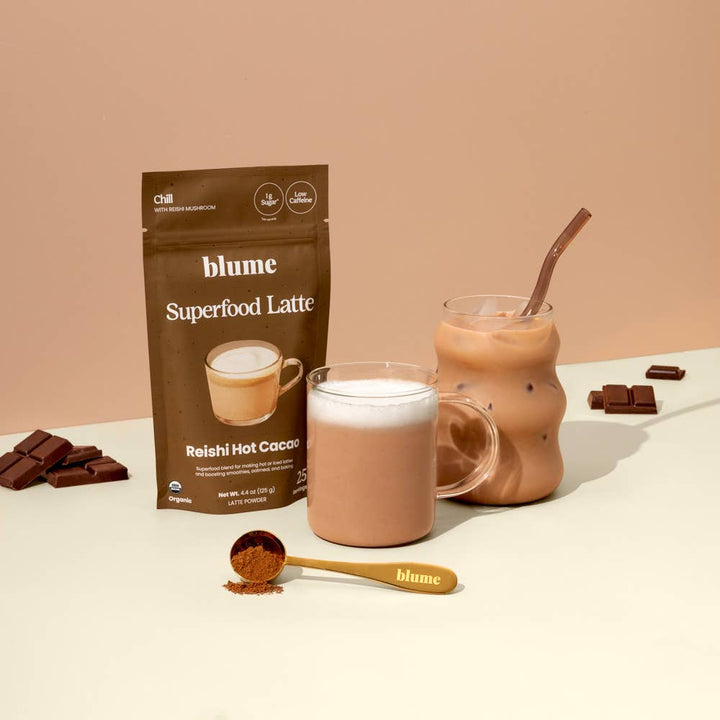 Blume Superfood Latte package with a glass of hot chocolate and ingredients on a beige background