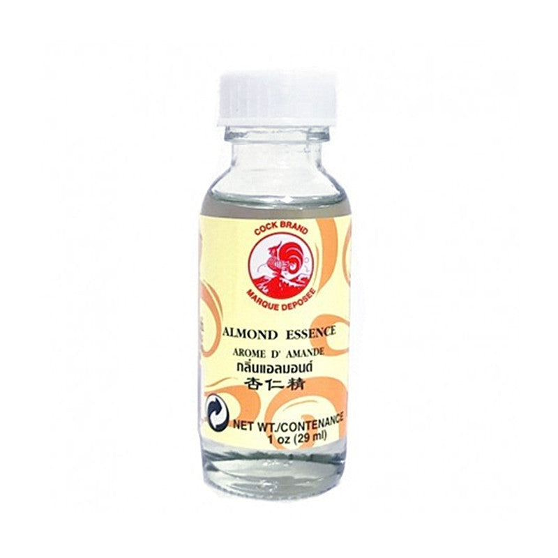 A glass bottle of Cock Brand Almond Essence with a label featuring a red and yellow design and the text &