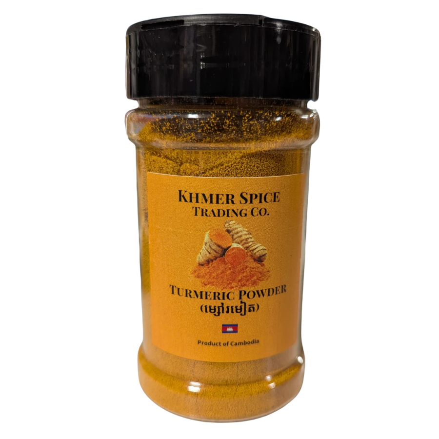 A clear plastic spice jar filled with golden-brown turmeric powder, topped with a black screw cap, and featuring a tan label that reads &