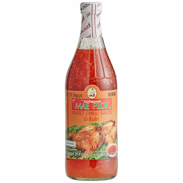 Bottle of Mae Ploy Sweet Chilli Sauce with a red label, showcasing the product name and an image of a dish possibly enhanced with the sauce.