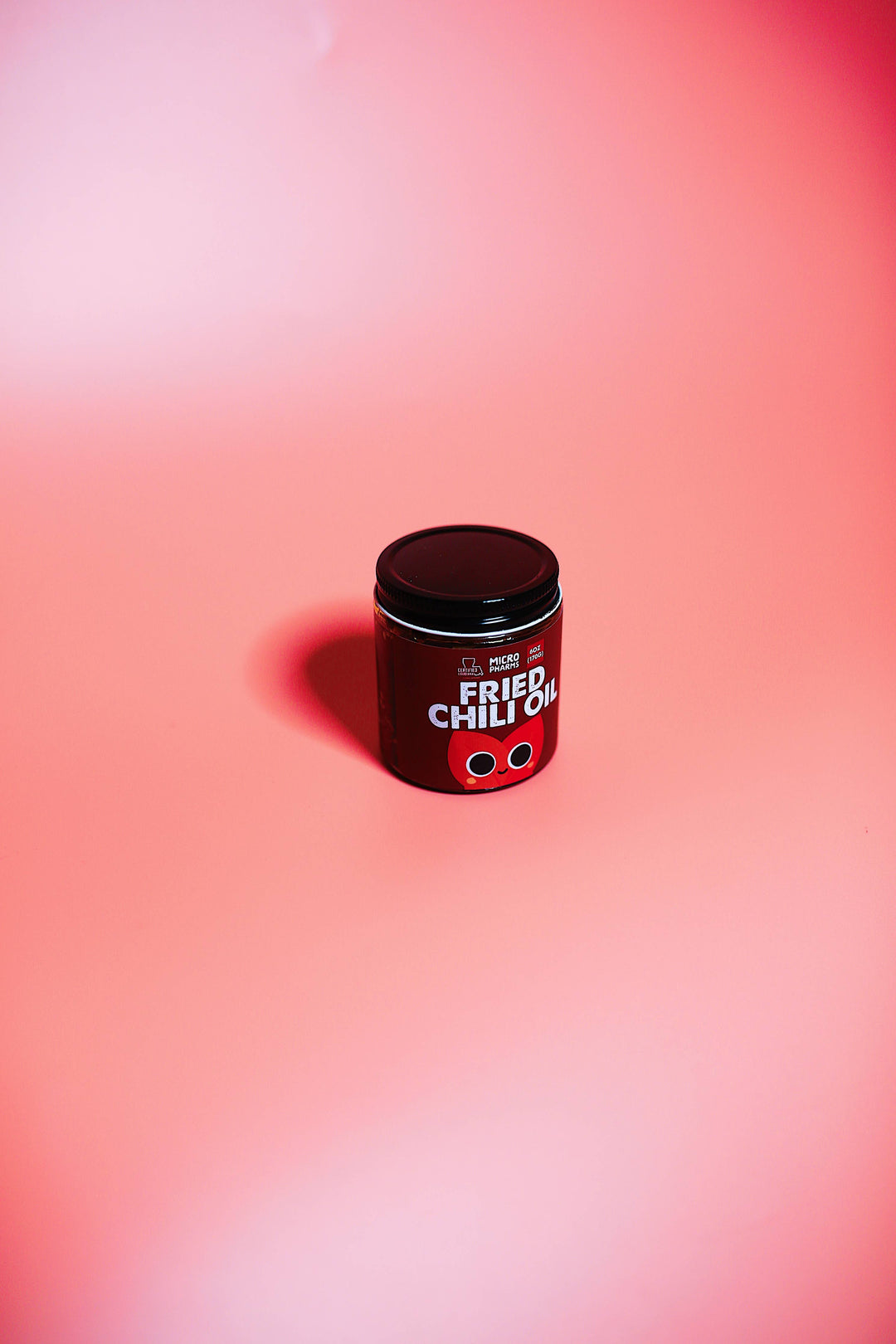 A small cylindrical black container labeled &