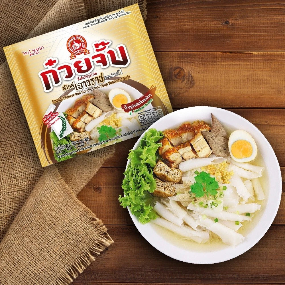 A bowl of Thai noodle soup with tofu, a hard-boiled egg, and green lettuce, placed on a wooden table next to its yellow and red No. 1 Brand package.