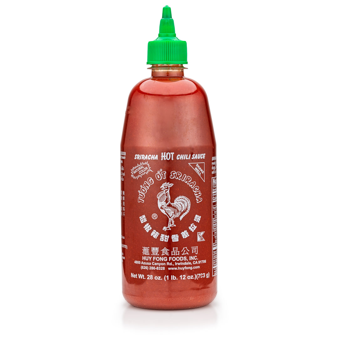 Bottle of Sriracha hot chili sauce with a green cap on a white background