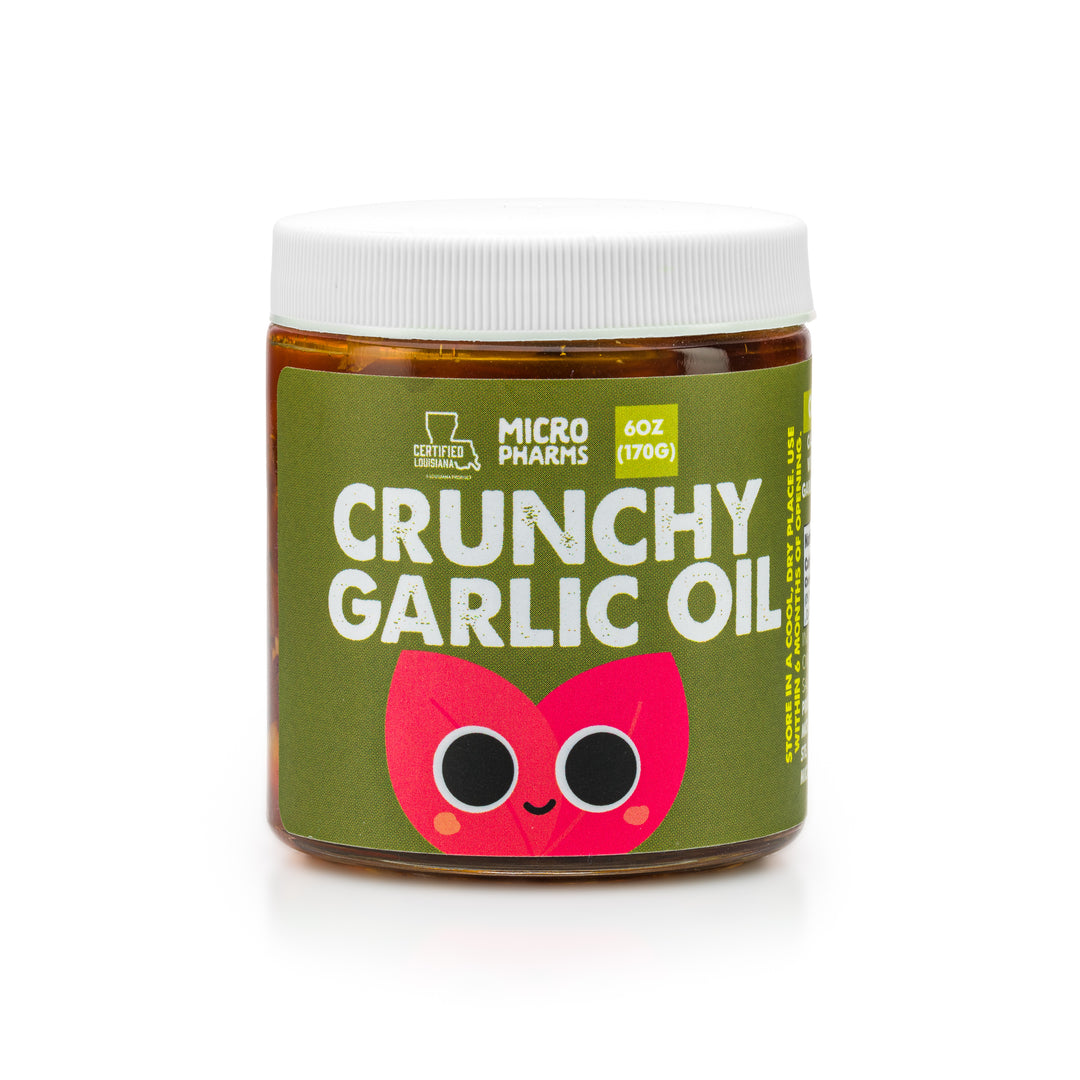 A jar of Micro Pharms Crunchy Garlic Oil with a label featuring a cartoon garlic character, indicating the flavor and organic qualities of the product.